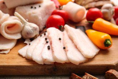 Masada tuzlanmış domuz yağı dilimleri olan ahşap tahta, yakın plan.