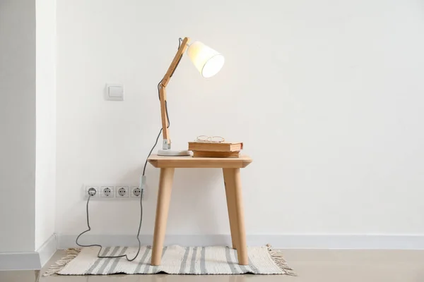 Işık Duvarının Yanındaki Masada Parlayan Lamba Kitaplar — Stok fotoğraf