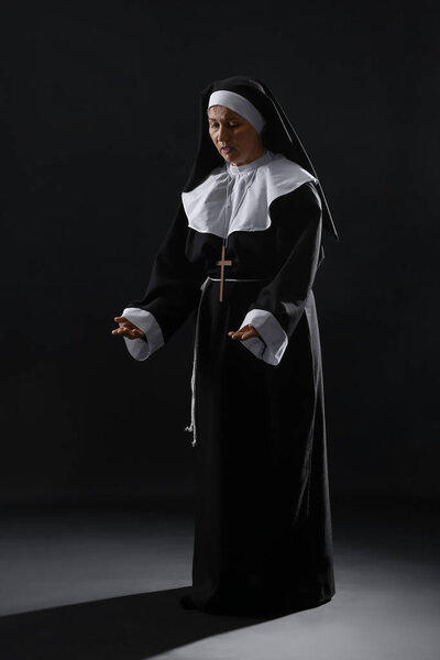 Зрелая монахиня на тёмном фоне