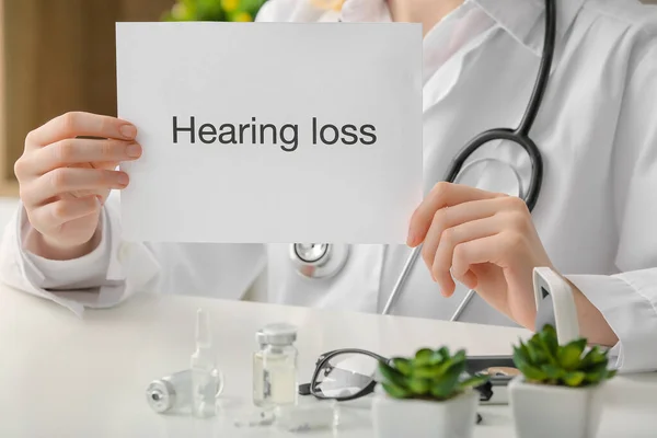 Female Doctor Holding Paper Text Hearing Loss Clinic — Stock Photo, Image