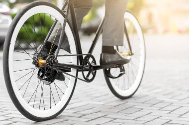 İş adamı şehir caddesinde bisikletle işe gidiyor.