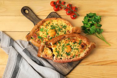 Lezzetli Ajarian khachapuri ve ahşap arka planda domatesli tahta.