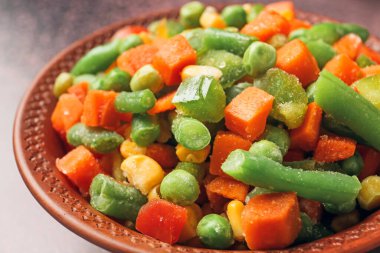 Farklı donmuş sebzelerle kase, yakın plan.