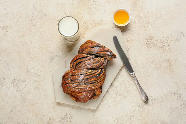 Lezzetli haşhaşlı çörek, bal ve arka planda bir bardak süt.