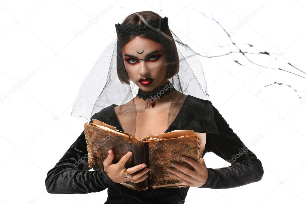 Young witch with spell book on white background