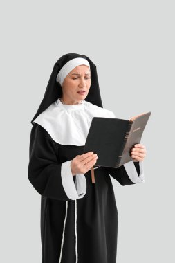 Olgun rahibe, arka planda İncil okuyor.