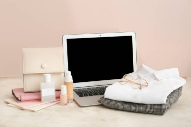 Kadın giysileri, aksesuarlar ve renk arkaplanındaki dizüstü bilgisayar