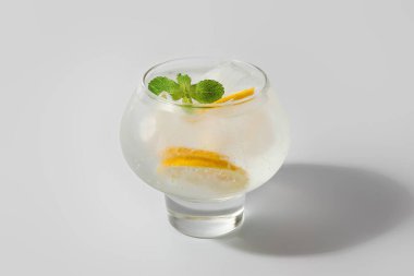 Beyaz arka planda bir bardak soğuk cin tonik.