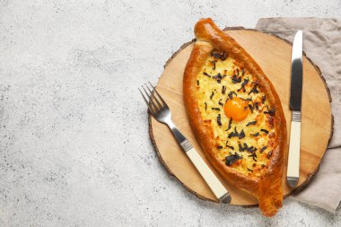 Hafif arka planda lezzetli Ajarian Khachapuri tahtasına sahip ahşap tahta.