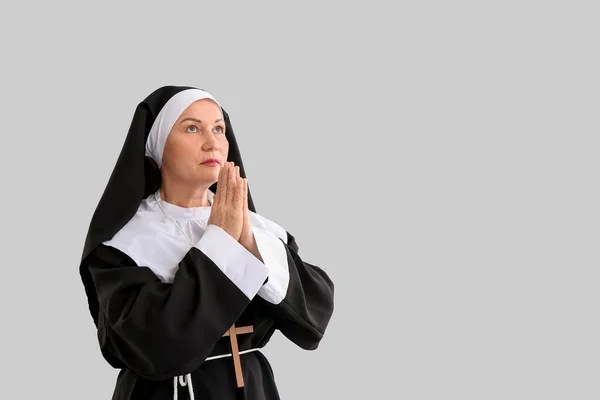 Зрелая Монахиня Молится Светлом Фоне — стоковое фото