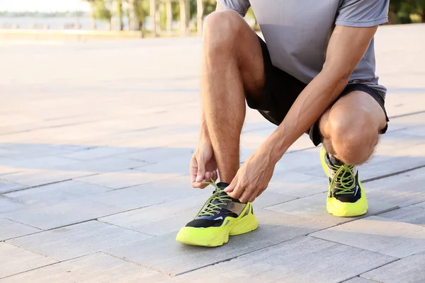 Sporty Young Man Tying Shoe Laces Outdoors — Stock Photo, Image