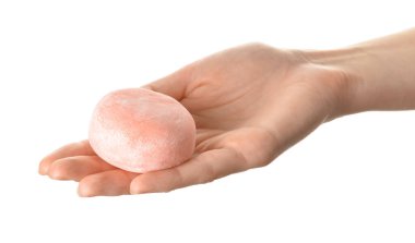 Beyaz arka planda lezzetli Japon mochi 'si olan kadın eli.