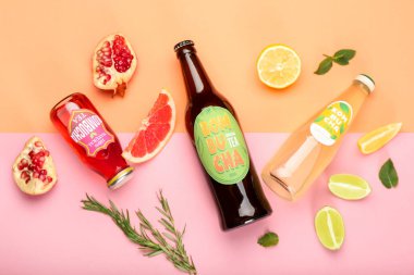 Şişe içinde farklı kombu çayı ve renkli arkaplanda meyve kompozisyonu