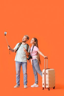 Renkli arka planda selfie çeken iki turist.