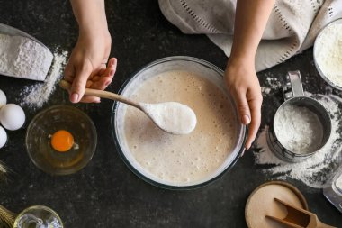 Kadın aşçı mutfak masasında hamur hazırlıyor, yakın plan.