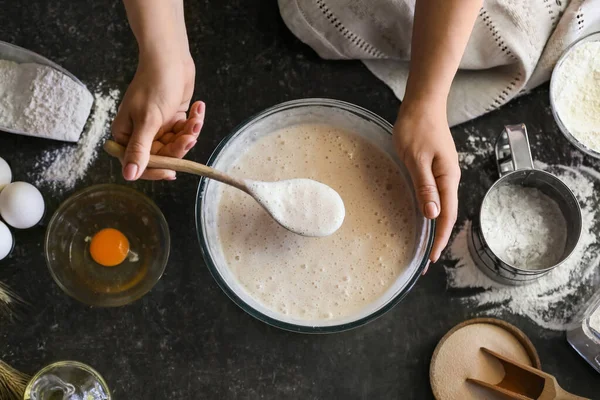 Kadın aşçı mutfak masasında hamur hazırlıyor, yakın plan.