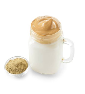 Mason kavanoz lezzetli dalgona hojicha latte ve beyaz arka planda pudra