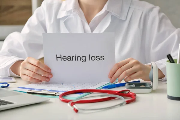 Female Doctor Holding Paper Text Hearing Loss Clinic — Stock Photo, Image