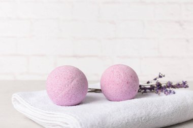 Lavanta banyosu bombaları ve hafif tuğla duvarın yanındaki havlu.