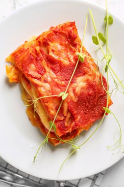 Tabakta domates sosu olan lezzetli bir lazanya, yakın plan.