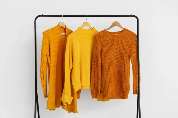 Rack Stylish Knitted Clothes Light Wall — Stock Photo, Image