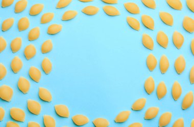 Renkli arka planda pişmemiş conchiglioni makarnadan yapılmış çerçeve