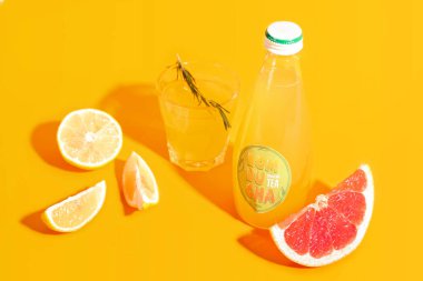 Renkli meyveli bir bardak ve bir şişe taze kombu çayı.