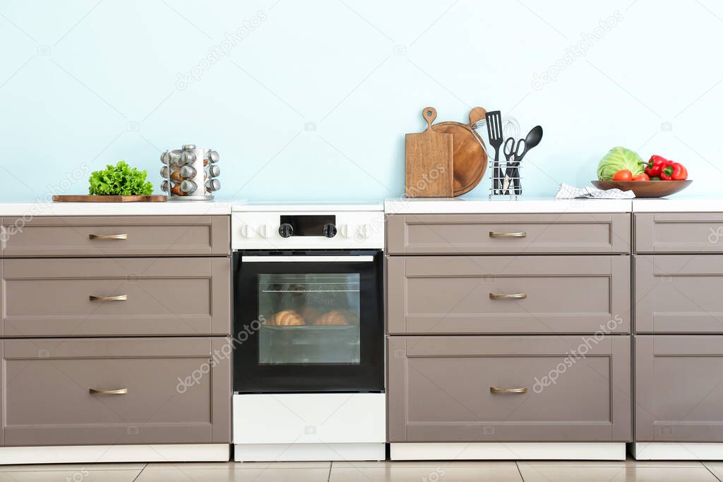 Modern furniture with electric oven near color wall in kitchen