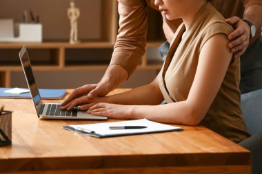 Patron sekreterini ofisinde taciz ediyor.