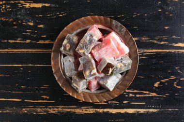 Koyu ahşap zemin üzerinde lezzetli Türk lokumu tabağı