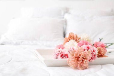 Yatakta bir buket güzel karanfil.