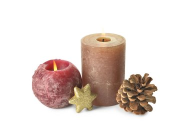 Beyaz arkaplanda mum bulunan Noel kompozisyonu