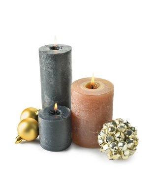 Beyaz arka planda yanan mumlarla ve Noel dekoruyla kompozisyon