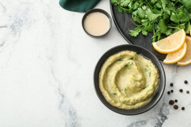 Hafif arka planda lezzetli baba ghanoush, limon ve baharatlı kase