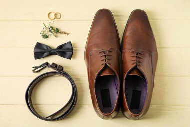 Alyanslar ve renkli ahşap arka planda şık damat aksesuarları