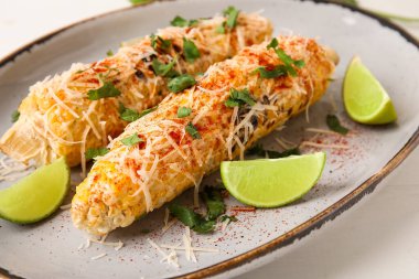 Beyaz arka planda lezzetli Elote Meksika sokak mısırı, yakın plan