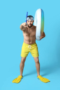 Renkli yüzüklü, kürekli ve şnorkelli genç bir adam.