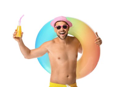 Beyaz arka planda şişme yüzük ve meyve suyu olan genç bir adam.