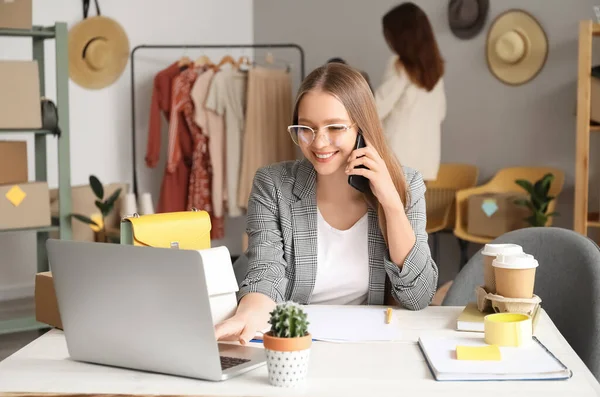 Female business owner processing order in shop