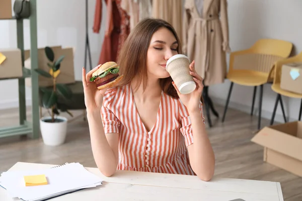 Female Seller Eating Tasty Vegan Burger Drinking Coffee Workplace — Stock Photo, Image