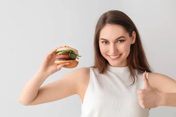 Beautiful Young Woman Tasty Vegan Burger Showing Thumb Light Background — Stock Photo, Image