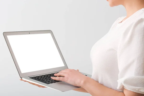 Красива Молода Жінка Тримає Ноутбук Порожнім Екраном Сірому Фоні — стокове фото