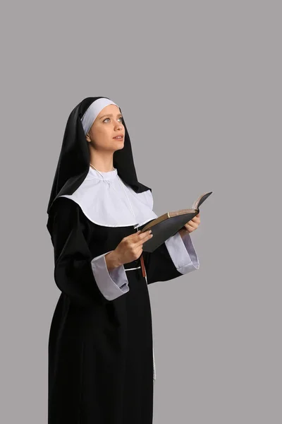 Молодая Монахиня Библией Сером Фоне — стоковое фото