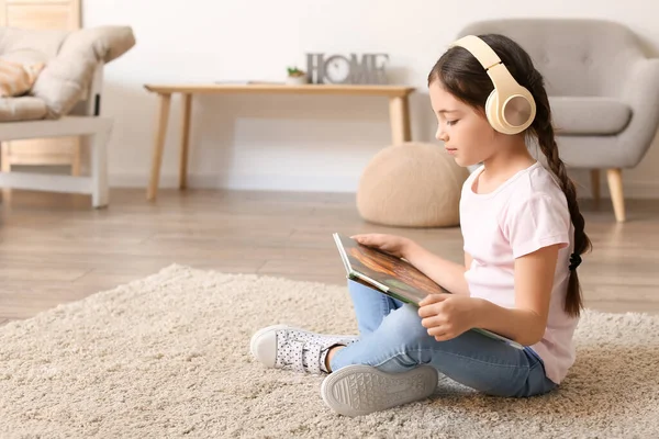 Little Girl Headphones Reading Book Home — Stock Photo, Image