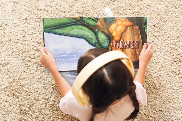 Little Girl Headphones Reading Book Home Top View — Stock Photo, Image