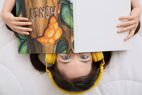 Mała Dziewczynka Słuchawkami Książki Sypialni Widok Góry — Zdjęcie stockowe