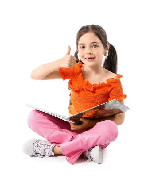 Dziewczynka Słuchawkami Książką Pokazującą Kciuk Góry Białym Tle — Zdjęcie stockowe