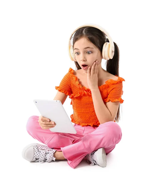 驚きの女の子とともにヘッドフォンとタブレットコンピュータ上の白い背景 — ストック写真