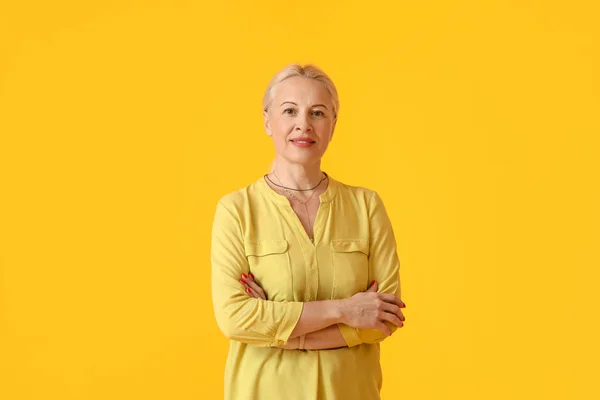 黄色の背景に成熟した女性の肖像画 — ストック写真