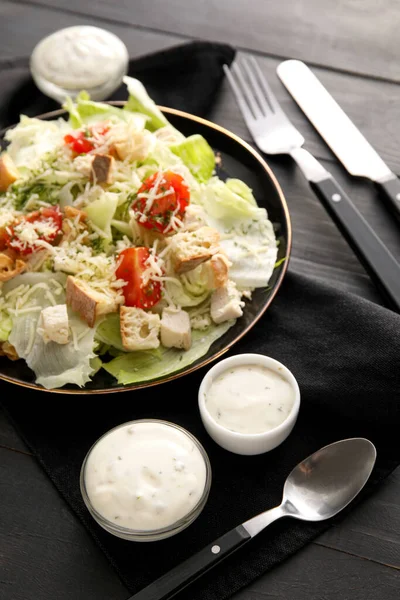 Prato Saborosas Tigelas Salada Caesar Com Molho Fundo Madeira Preta — Fotografia de Stock